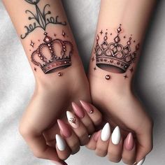 two girls with matching tattoos on their arms and hands, one has a tiara