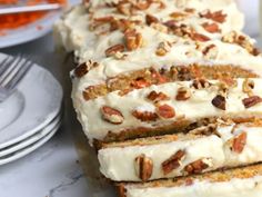 slices of carrot bread with cream cheese frosting and pecans on the top one