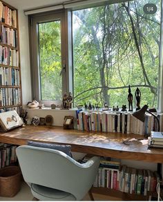 a chair sitting in front of a window next to a book shelf filled with books