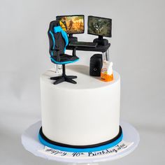 there is a cake with a computer on it and a chair in front of it