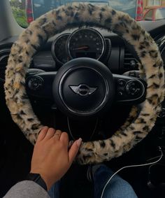 a person driving a car with a steering wheel cover