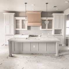 an empty kitchen is shown with white cabinets and gray counter tops in the process of remodeling