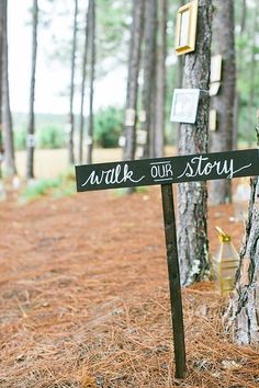 a sign that is on the side of a tree in the grass with words written on it