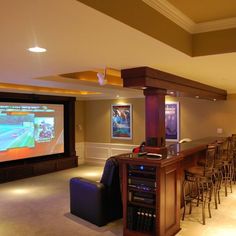 a home theater with bar seating and large screen