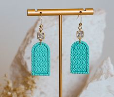 Gorgeous embossed turquoise arches featuring a gold plated square cubic zirconia charm. Handmade in Geraldton, Western Australia. These lightweight earrings are made with real gold electroplated jump rings and earwires. All findings are lead and nickel free. Each earring measures approximately: 57mm total length 39mm drop length (from top of CZ connector to bottom of clay component) 30mm (clay component) 17mm at the widest point Each item is carefully handmade from high quality polymer clay, and no two are identical. Small blemishes, fingerprints, and asymmetries occur, but I feel these imperfections only add to the charm of a piece. I do my best to display the true colours and details of each item, but variations in lighting conditions and device displays can affect how they appear. Polym Earring Cards, Lightweight Earrings, Light Weight Earrings, Western Australia, Jump Rings, Real Gold, Handmade Earrings, True Colors, Favorite Jewelry