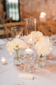 white flowers and candles are on the table