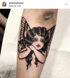 a woman's face with an angel tattoo on her arm and leg, in black ink