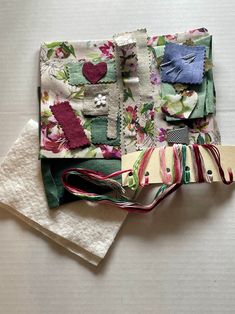 several pieces of fabric are stacked on top of each other, including one with flowers and hearts