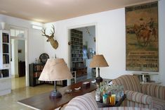 a living room filled with furniture and a deer head mounted to the wall above it