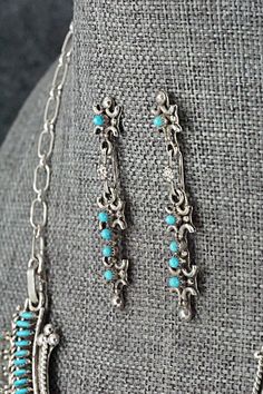 This beautiful turquoise and sterling silver necklace and earrings set was made by Zuni silversmith Connie Wyaco. The back of the pendant is signed.Necklace: 14"Pendant Length: 1 1/2"Pendant Width: 1 1/2"Station Length: 1 1/2"Station Width: 3/4"Earrings:Length: 1 1/2"Width: 1/4"Free shipping on all orders! We ship with USPS and always include tracking. All orders ship within a day of payment.Returns are accepted up to 30 days after you receive your order. Just send us a message. Our shop offers Elegant Sterling Silver Turquoise Dangle Necklace, Elegant Silver Dangle Turquoise Necklace, Southwestern Silver Jewelry For Weddings, Elegant Silver Turquoise Dangle Necklace, Southwestern Silver Jewelry For Wedding, Southwestern Style Silver Jewelry For Weddings, Southwestern Silver Wedding Jewelry, Silver Turquoise Dangle Necklace In Sterling Silver, Turquoise Dangle Necklace In Sterling Silver