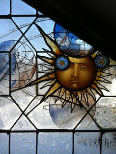 a stained glass window with a sun face on it