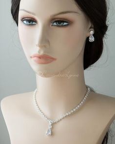 a mannequin head with a necklace and earring on it's neck