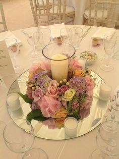 the centerpiece is surrounded by flowers and candles