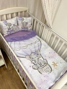 a baby crib with an elephant bedding set