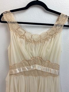 "1950's Vanity Fair Nightgown This cream colored nightgown is dreamy. She is a 1950's Vanity Fair size 32 Tricot Nylon two layer night gown trimmed in lace. She has two ribbon waist ties for decoration. Measurements provided are flat and have been doubled. Bust 32\" Waist 26\" Hips free Length 40\" ❤️ Condition: Excellent vintage condition. Flaw: waist tie ribbons have a few flaws, but they are not noticeable when worn. Please see pic. This item has been cleaned and is ready to wear. $68 include Cream Wedding Night Gown With Lace Trim, Vintage Nightgown With Delicate Lace For Wedding Night, Empire Waist Lace Trim Nightgown For Wedding Night, Elegant Empire Waist Lace Trim Nightgown For Wedding Night, Sleeveless Cream Nightgown For Wedding, Elegant Lace Trim Empire Waist Nightgown For Wedding Night, Wedding Night Lace Trim Empire Waist Nightgown, Wedding Night Nightgown With Lace Trim And Empire Waist, Vintage Sleeveless Lace Nightgown