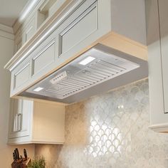 a stove top oven sitting inside of a kitchen next to white cabinets and counter tops