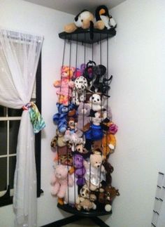 there is a rack with stuffed animals on it in the corner next to a window