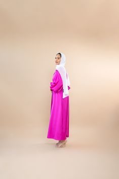 Model is 5'5 *Please note that the color displayed in the picture might be slightly different due to the color resolution and lighting. A vibrant color is what you're missing in your Abaya collection. Jamila is a glamorous piece designed from an Italian satin fabric which is known for its smoothness and luxurious shine. There are so many ways to style this luxe Abaya, pair it with our black or white feather pants, and your favorite strappy heels. Complete the look with either a sateen or chiffon Hijab for the ultimate statement. Fabric Description & Care: Material: Italian Satin Features: Rhinestone buttons at the front,belt, balloon sleeves Dry Clean or Handwash/ Do not tumble dry, soak or rub Steaming or Cool iron with cover cloth is recommended to avoid damage to fabric *When trying thi Pink Long Abaya For Eid, Long Pink Abaya For Eid, Pink Maxi Length Thobe For Eid, Pink Maxi-length Thobe For Eid, Pink Long Maxi Dress For Eid, Long Sleeve Pink Khimar For Eid, Pink Long Sleeve Abaya For Eid, Modest Long Pink Abaya, Modest Pink Abaya For Eid