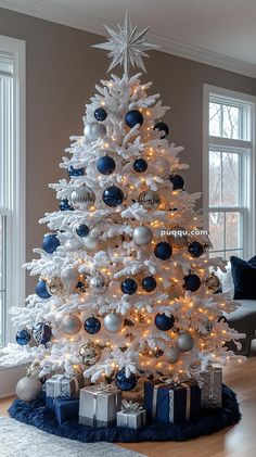 a white christmas tree with blue and silver ornaments