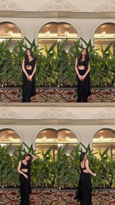 a woman in a black dress standing next to plants