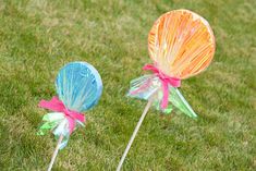 two candy lollipops sitting in the grass