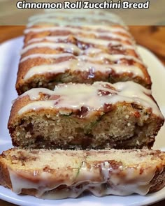 a loaf of cinnamon roll zucchini bread with icing on a white plate