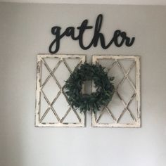 a white wall with two wreaths and the word gather on it