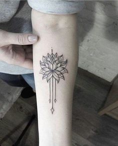 a woman's arm with a tattoo on it that has a flower in the center