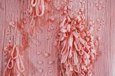 an image of pink fabric with flowers and beads on the back side, close up