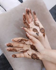 two hands with henna designs on them