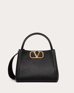 Valentino Garavani Alltime medium handbag in grainy calfskin with metallic VLogo Signature element. The bag can be worn on the shoulder/crossbody thanks to the shoulder straps or carried by hand thanks to the leather handles. - Antique brass-finish hardware - Magnetic closure - Adjustable and detachable ribbon shoulder strap - Adjustable and detachable leather shoulder strap - Protective feet - Interior: one zipped pocket - Leather shoulder strap drop length: 50 cm / 19.7 in. - Dimensions: W26xH Studded Sneakers, Oxford Boots, Bags And Purses, Medium Handbags, Valentino Rockstud, Armani Wallet, Ferragamo Belt, Fendi Belt, Chanel Belt