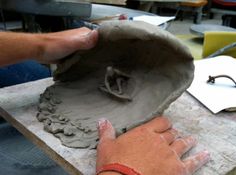 a person is working with clay on a table