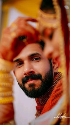 a man with a beard is looking at the camera while wearing an orange and gold outfit