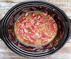 a crock pot filled with food on top of a wooden table