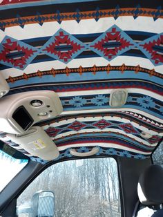 the interior of a car with an intricate design on the ceiling and dash board area