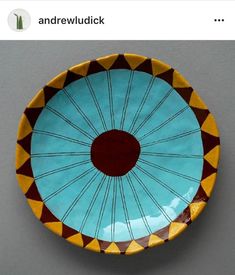 a blue and yellow plate with an orange circle on the center is shown in this photo