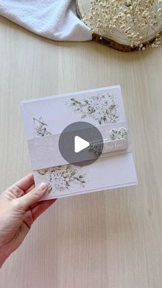 someone is holding up a card that has flowers on it and the video below shows how to fold