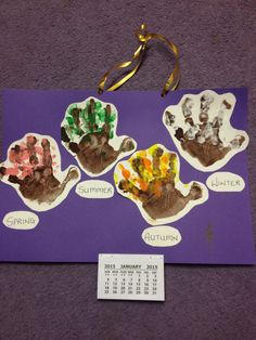 a bulletin board with handprints on it and a calendar hanging from the wall