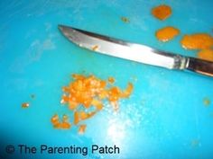 an orange peel on a cutting board next to a knife