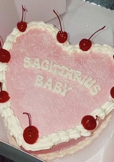 a heart shaped cake with cherries on the top and writing'sagitropus baby '