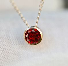 Genuine earth mined AA garnet set in 14k gold. Stone Size : 4mm Necklace Length : see options Metal : 14k Gold Gemstone : 0.3 cts Earth Mined AA Garnet Packaging : All products purchased from us come in a gift box. If you need to include a message, kindly leave us a note when purchasing. Care Recommendations: When not in use, keep earrings enclosed in a box or pouch to minimize exposure to moisture in air. Do not spray aromatics directly onto product. Minimize exposure to water. Clean with a sof Red Round Stone Jewelry With Bezel Setting, Minimalist Red Gemstone Birthstone Necklace, Red Round Pendant Jewelry With Bezel Setting, Red Round Stone 14k Gold Jewelry, Red 14k Gold Jewelry With Round Stone, Minimalist Red Birthstone Necklace, Red Birthstone Necklace In 14k Gold, Red Jewelry With Bezel Setting For Gift, Red 14k Gold Birthstone Necklace With Round Pendant