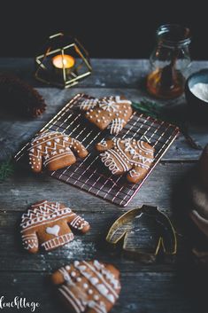 some cookies are on a cooling rack next to candles and other items that include pine cones