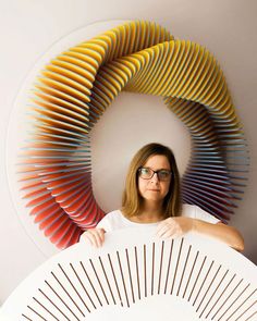 a woman with glasses is holding an art object