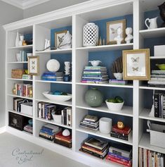 a bookshelf filled with lots of books and vases on top of it