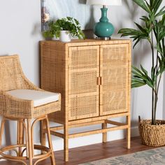 a wicker cabinet and stool in a living room with potted plants on the side