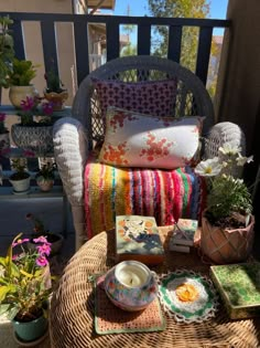 a wicker chair sitting on top of a wooden table next to potted plants