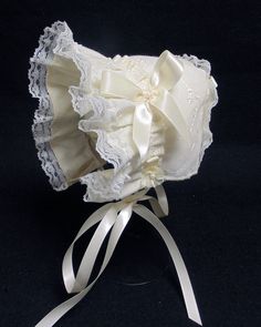 New handmade ivory eyelet summer bonnet with 3/8 inch ivory satin ribbon bows and ties * Ivory eyelet cotton blend fabric * Ivory  lining * Ivory lace * Ivory  bows and ties Size/ measurement from under ear lobe around top of head to under other ear lobe preemie / 10 inches 0-3 months / 11 inches 3-6 months / 12 inches 6-9 months / 13 inches 9-12 months / 14 inches White Adjustable Lace Bonnet, White Lace Adjustable Bonnet, Adjustable Cream Bonnet For Baptism, Fitted Cotton Cream Bonnet, Fitted Cream Bonnet With Lace Trim, Satin Ribbon Bow, Rising Sun, Ivory Lace, Ribbon Bows