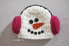 a crocheted snowman hat with earphones on it's headband