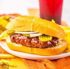 a meatball sandwich with pickles and onions on a plate