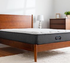 an image of a mattress on top of a wooden bed frame in a bedroom setting